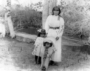Jessie Durant is in the papoose next to her mother and sister along Rush Creek, 1913.